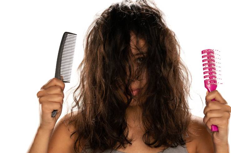 Donna con capelli crespi e spazzola in mano