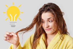 Donna che guarda capelli e lampadina per idea