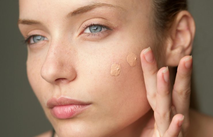 Donna che applica fondotinta